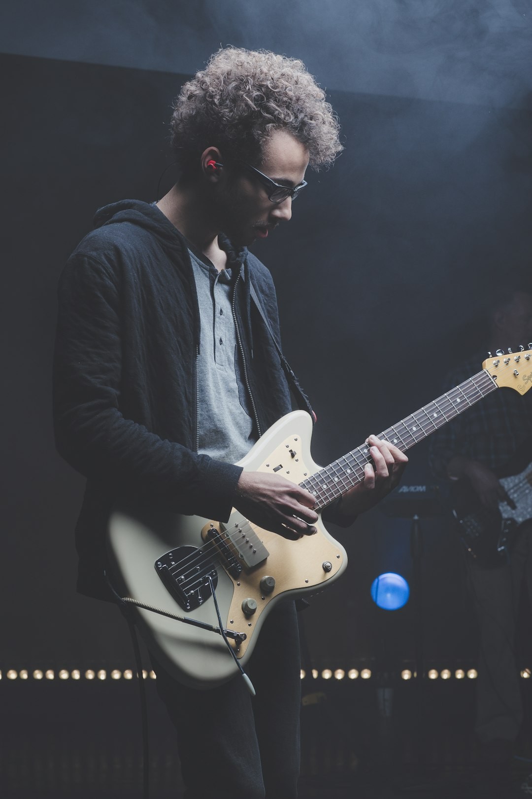 Guitarist in glasses performing live