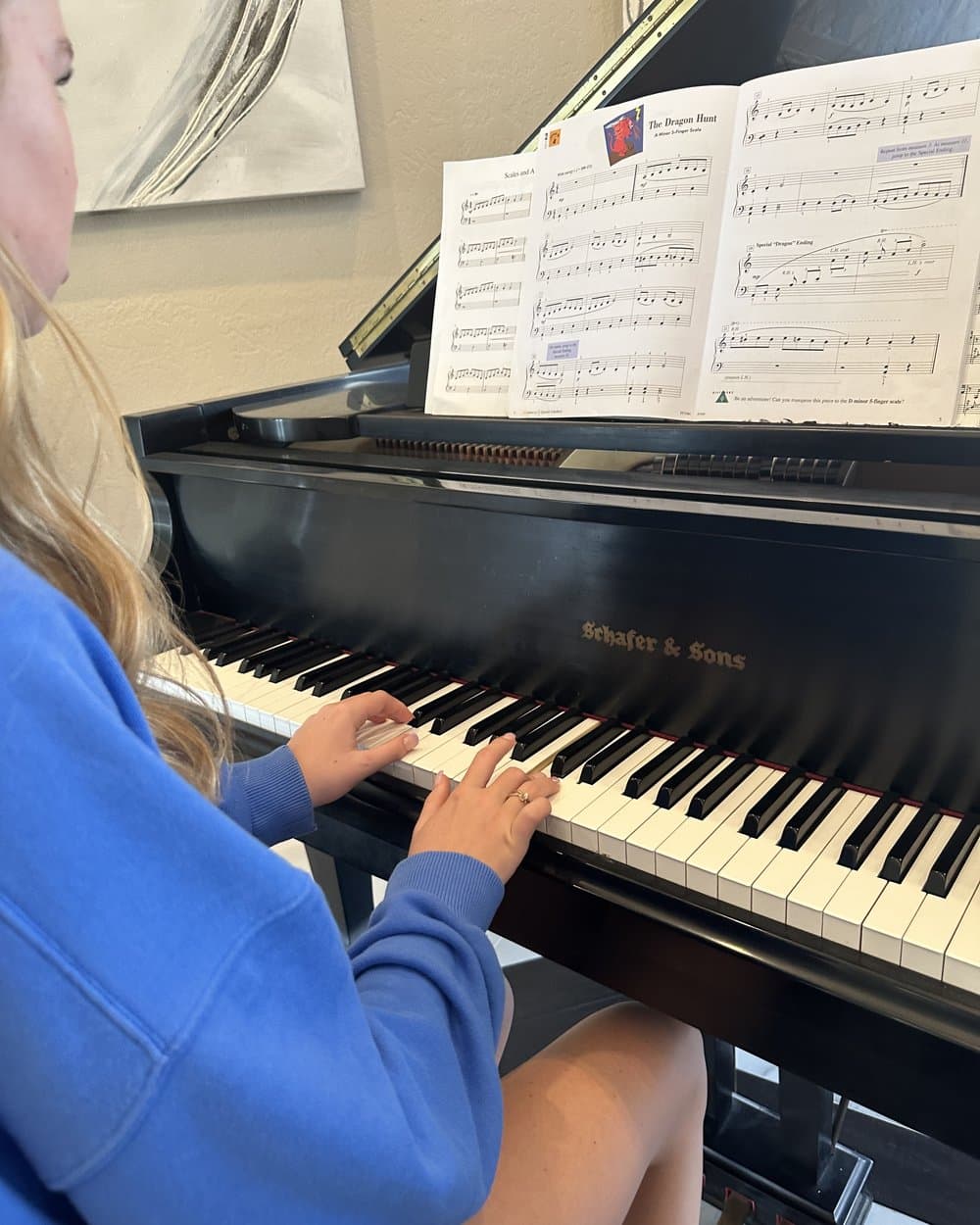 A student at the piano with her method book